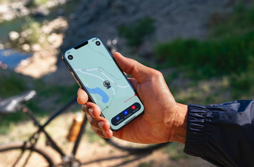 Close-up of a smartphone displaying a live GPS map, showcasing OnStar Guardian app features outdoors